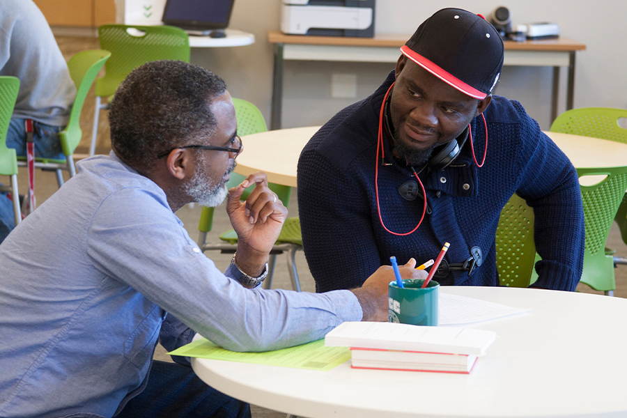 Advisor and student in conversation at a table during an academic advising appointment